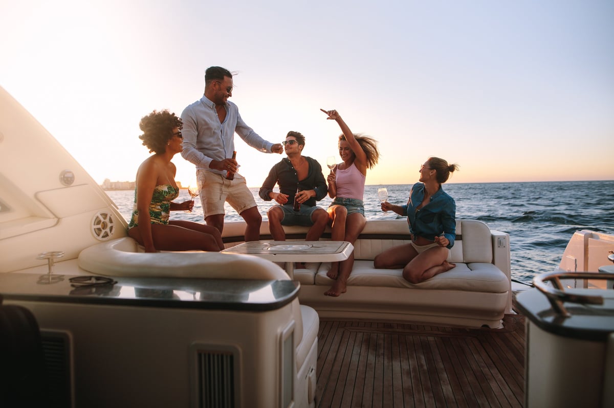 Friends dancing and celebrating at a sunset yacht party